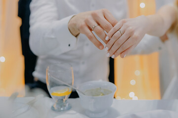 Close-up of bride and groom hands with gold wedding rings, showing love, marriage, and lifelong commitment