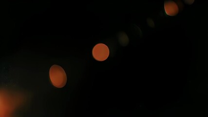 Abstract image of blurred orbs in varying sizes against a dark, black backdrop - Powered by Adobe
