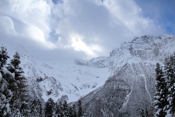 Snow-covered mountain peaks under a dramatic winter sky