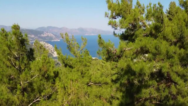 aerial footage captures the stunning panoramic vista of Turunc Bay near Marmaris, Turkey, showcasing the vibrant turquoise waters of the Aegean Sea, lush green mountains, and the picturesque coastal s