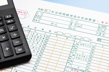 青色申告決算書と電卓を使った確定申告の準備イメージ