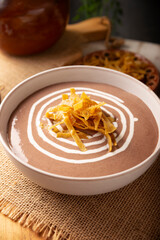 Creamy bean soup. In Mexico known as Crema de Frijoles, nutritious homemade food recipe, commonly accompanied with cheese, cream, avocado and corn tortilla cut into strips and fried.