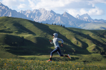 Trail runner running  on the high altitude grassland mountain top