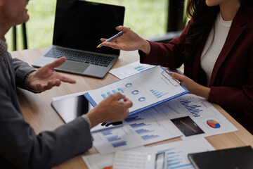 Businessman and businesswoman with plan analysis at desk in modern office, Documents discussion analysis data the charts graphs, Business financial information and Asian accountant concept.