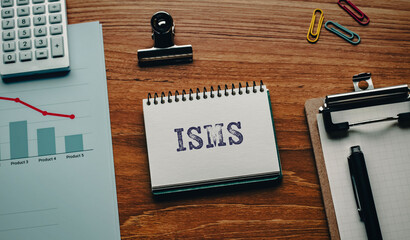 There is notebook with the word ISMS. It is an abbreviation for Information Security Management System as eye-catching image.