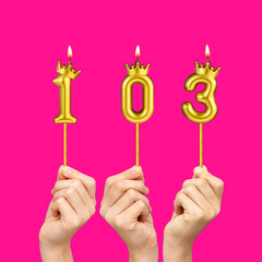 Hands holding number shaped candles - Birthday number 103