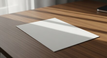 Fototapeta premium Blank White Paper on Wooden Desk in Bright Light