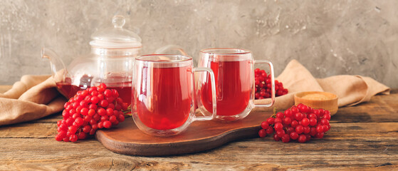 Cups of healthy viburnum tea on table