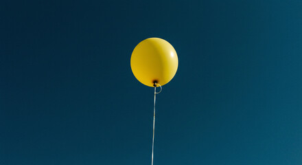 Obraz premium Bright yellow balloon floats joyfully, perfect for birthday celebrations, party announcements, or uplifting designs needing a touch of happy innocence