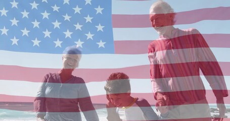 Patriotic family walking on sandy beach exiting frame culminating in animated American flag overlay - Powered by Adobe