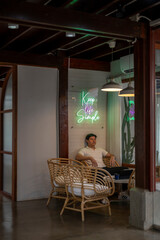 Entrepreneur relaxing in modern office with keep life simple neon sign