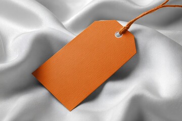 Orange price tag on draped, white fabric