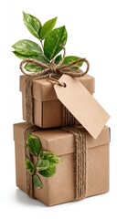 Two stacked, kraft paper gift boxes, decorated with twine and fresh green leaves, with a blank tag