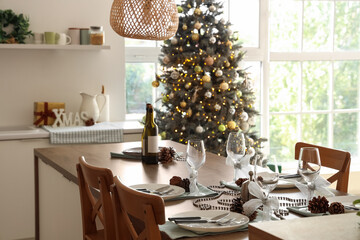 Christmas table setting with fir cones in kitchen