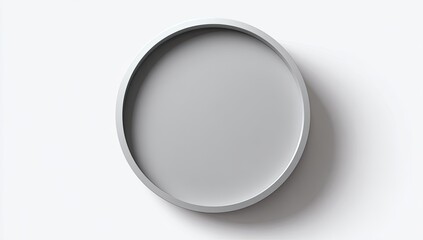 A circular, gray tray casts a subtle shadow on a white backdrop, viewed from above