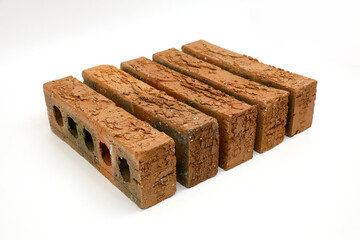 Row of rough clay bricks showing texture on white backgroundRow of rough clay bricks showing texture on white background