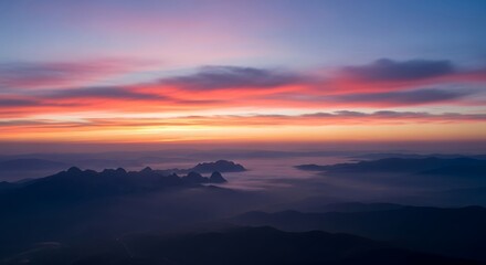 Obraz premium Magnificent aerial view of mountain peaks rising through fog at colorful sunrise Awe Inspiring