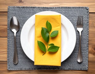 Table setting with yellow napkin and green leaves