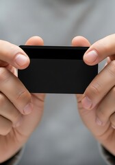 Hands presenting a sleek black card for cashless transactions concept