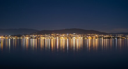 Obraz premium Tranquil nightscape showcasing a city's luminous reflections on a serene body of water