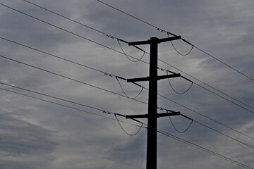 Silhouette of High voltage transmission lines with jumper cables on stormy day