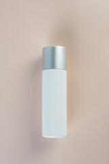 Cosmetic product in tube, bottle, lotion or serum with stylish props on light brown background. 