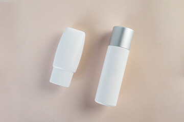 Cosmetic product in tube, bottle, lotion or serum with stylish props on light brown background. 