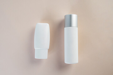 Cosmetic product in tube, bottle, lotion or serum with stylish props on light brown background. 