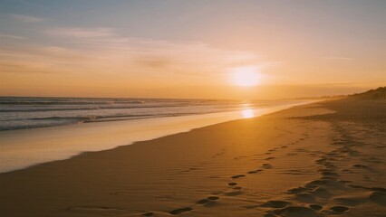 Obraz premium Sunset over a sandy beach with footprints leading toward the ocean