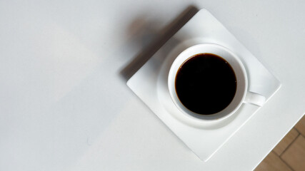 Coffee in a white cup on a white plate