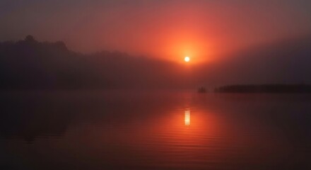 Fototapeta premium Misty sunrise over a lake. Sunrise reflects on water