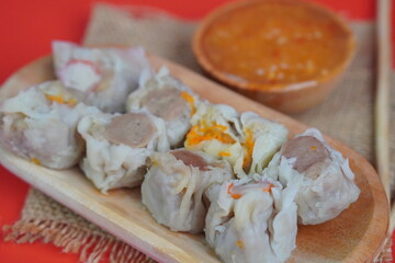 Dim Sum with Sauce on Red Background