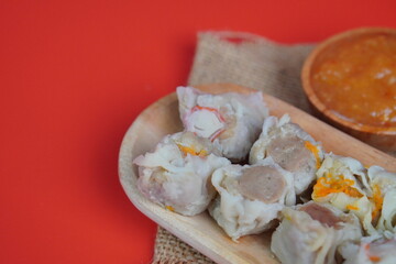 Dim Sum with Sauce on Red Background