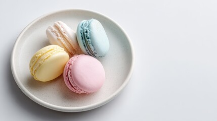 Three different colored macarons in a white bowl