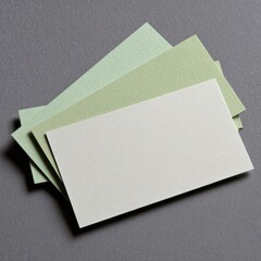 Three pale green and white business cards