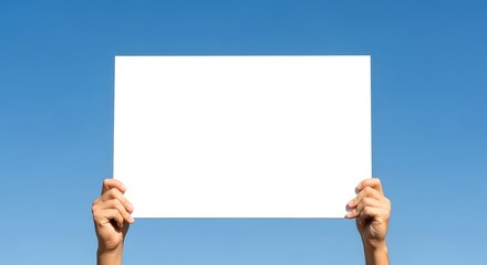 Person holding blank white sign against clear blue sky background for marketing or message display