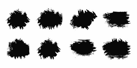 Collection of eight black abstract grunge brush stroke splatters on a white background