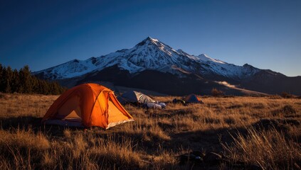Sunrise campsite at foot of snow-capped mountain