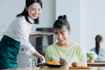 カフェで料理を配膳する若い女性