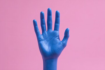 Blue painted hand with fingers outstretched, on a vibrant pink backdrop, minimalist aesthetic