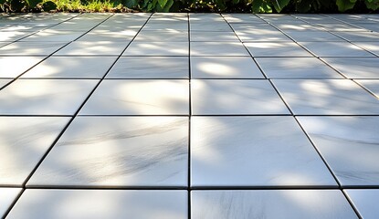 Smooth tiles under sunlit leaves, clean, even grid pattern