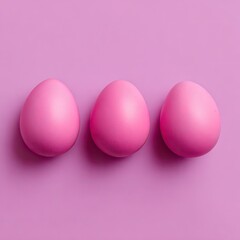 Three pink eggs arranged in a horizontal line on a solid, matching pink background