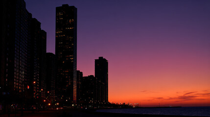 Fototapeta premium Stunning cityscape at sunset with tall buildings along the waterfront