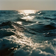 Close-up view of ocean waves at sunrise/sunset. Sun's reflection on water's surface