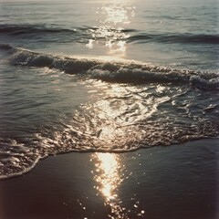 Gentle ocean waves reflecting golden sunlight on a beach