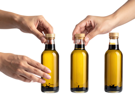 Three hands opening and closing lids on small bottles of oil