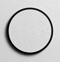Close-up of a textured white circle inside a black outline on a textured off-white background