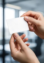 Person Holding Blank Card Displaying in Office Environment Suggesting Professional Networking