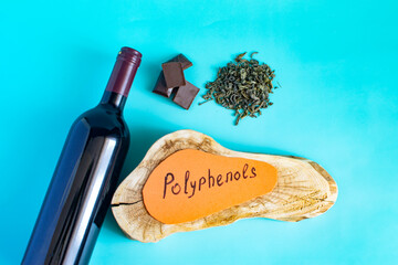 Products containing useful substances and polyphenols in their composition. Chocolate, green tea, wine in close-up on a light background and the inscription "polyphenols".