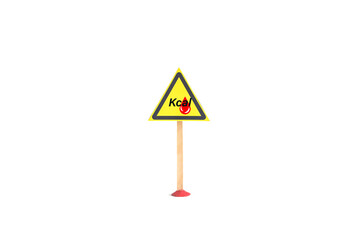 The warning sign "high-calorie food" in the form of a yellow triangle on a stand, close-up on a light background, isolate. The concept of a warning sign about high-calorie foods